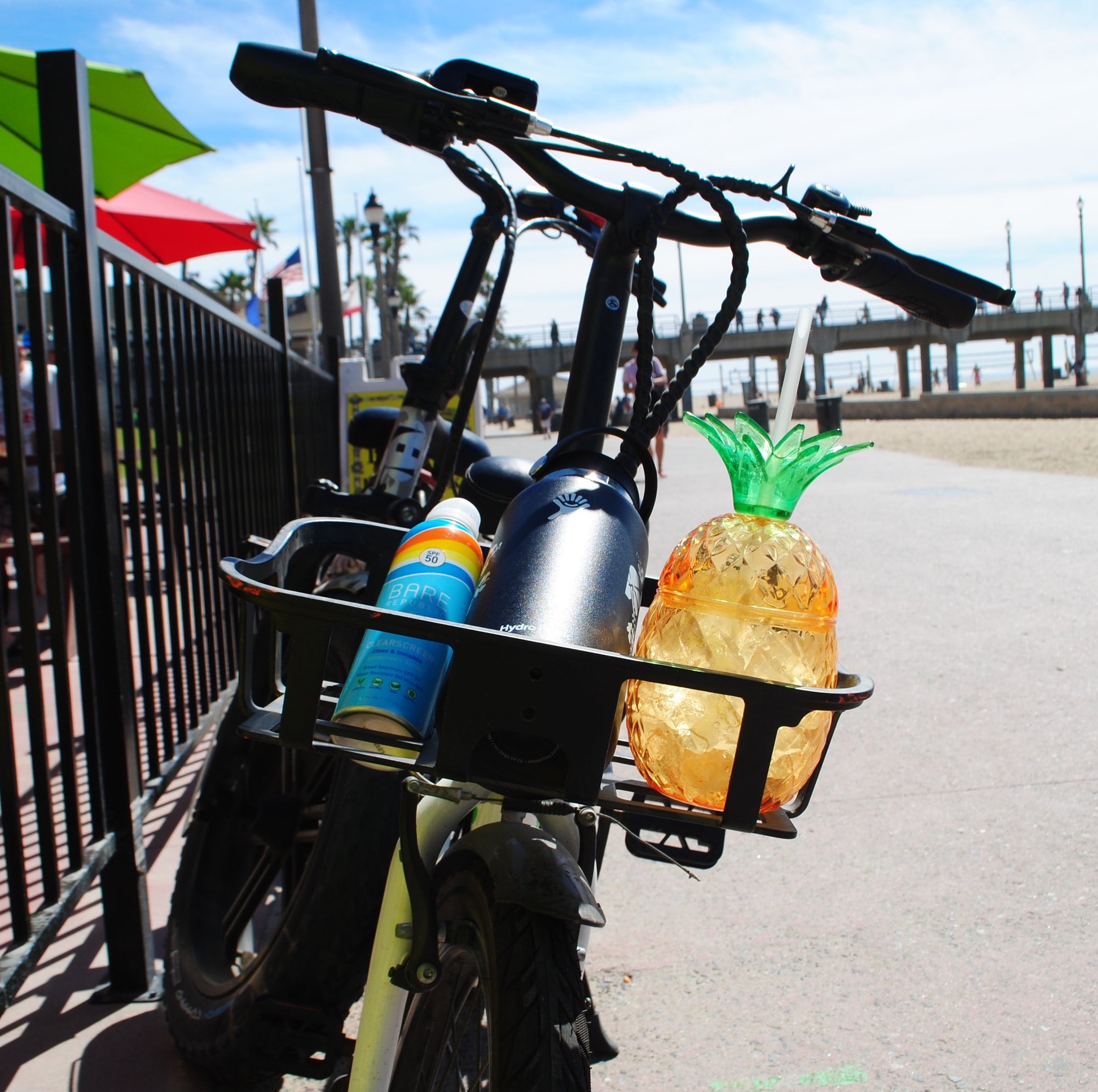 Electric bicycle and basket with sunscreen, a water bottle, and refreshment.