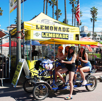 Pedal Limousine with girls riding by the Lemonade stand.