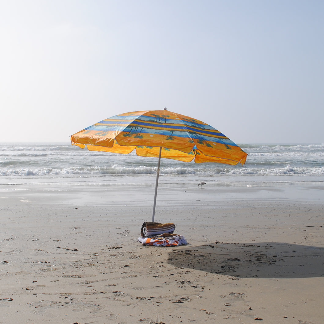 Beach umbrella, beach towels, and beach blanket in Huntington Beach, Orange County, a 40 minute drive from Los Angeles International Airport in California.